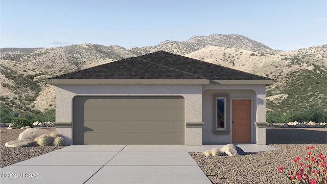 ranch-style house featuring a mountain view, a shingled roof, a garage, concrete driveway, and stucco siding