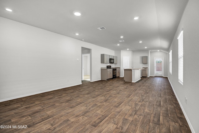 unfurnished living room featuring recessed lighting, dark wood-style flooring, baseboards, and visible vents