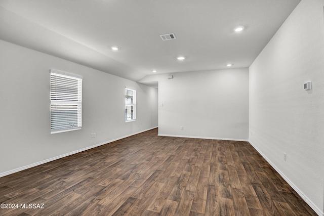 unfurnished room with dark wood-type flooring, baseboards, visible vents, and recessed lighting