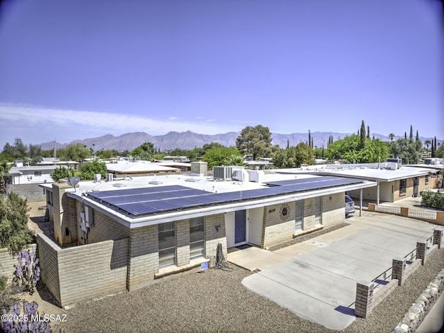 7217 E Fayette St, Tucson, AZ 85730 - view of front facade featuring a mountain view, roof mounted solar panels, brick siding, and covered porch