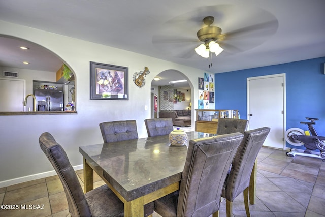 7217 E Fayette St, Tucson, AZ 85730 - dining space with arched walkways, a ceiling fan, tile patterned floors, and baseboards