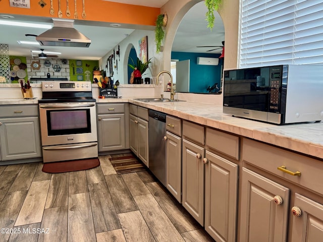 7217 E Fayette St, Tucson, AZ 85730 - kitchen featuring appliances with stainless steel finishes, ceiling fan, a sink, wall chimney exhaust hood, and gray cabinets