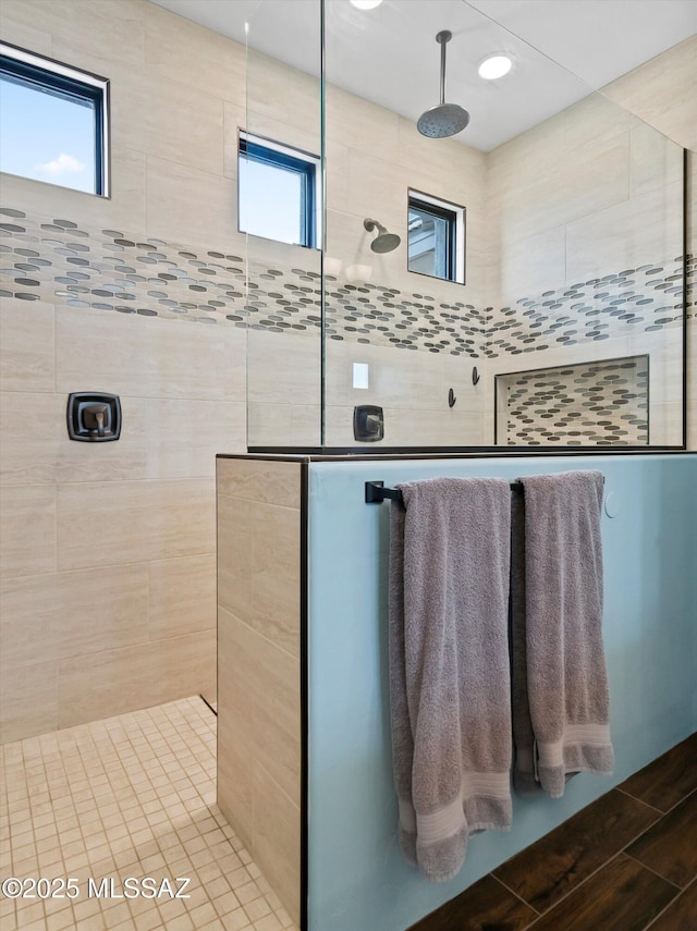 full bathroom featuring a tile shower and a healthy amount of sunlight