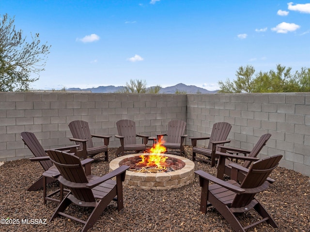 view of patio / terrace with a mountain view, fence, and a fire pit