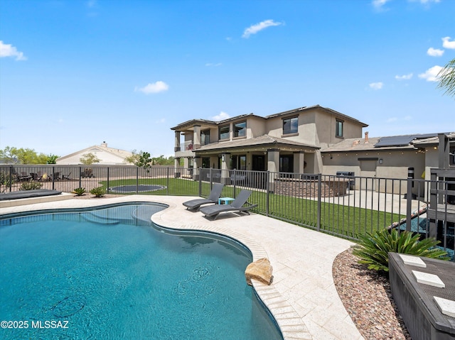 view of swimming pool featuring a patio, a yard, a fenced in pool, and fence
