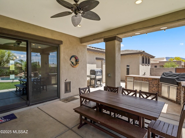 view of patio / terrace featuring area for grilling, outdoor dining area, fence, and exterior kitchen