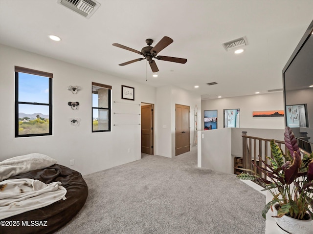 sitting room with recessed lighting, carpet flooring, visible vents, and an upstairs landing