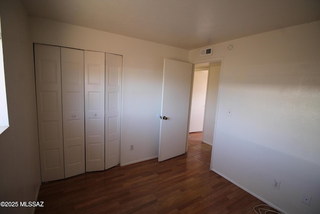 2665 N Leah Pl, Tucson, AZ 85705 - unfurnished bedroom featuring wood finished floors, baseboards, and a closet