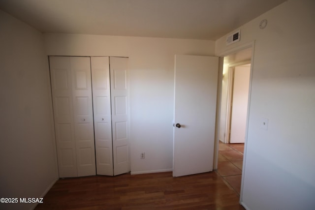 2665 N Leah Pl, Tucson, AZ 85705 - unfurnished bedroom featuring wood finished floors, a closet, and baseboards