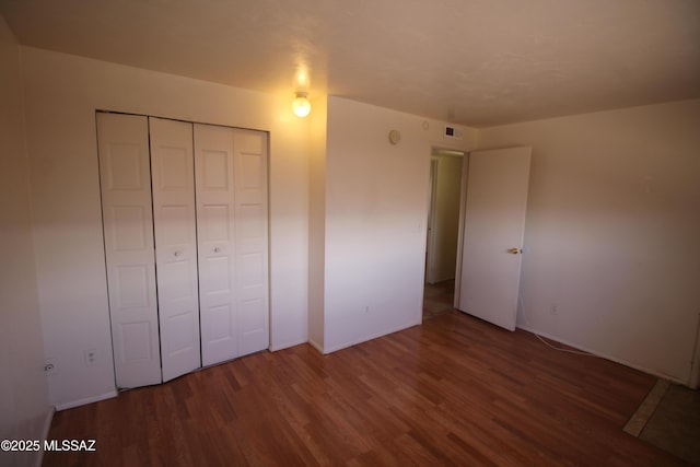 2665 N Leah Pl, Tucson, AZ 85705 - unfurnished bedroom featuring wood finished floors, a closet, and baseboards
