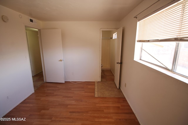 2665 N Leah Pl, Tucson, AZ 85705 - unfurnished bedroom featuring light wood-type flooring and baseboards