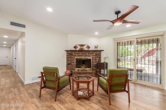 6821 N Cassim Pl, Tucson, AZ 85704 - sitting room featuring ceiling fan, light wood-style flooring, recessed lighting, a fireplace, and baseboards