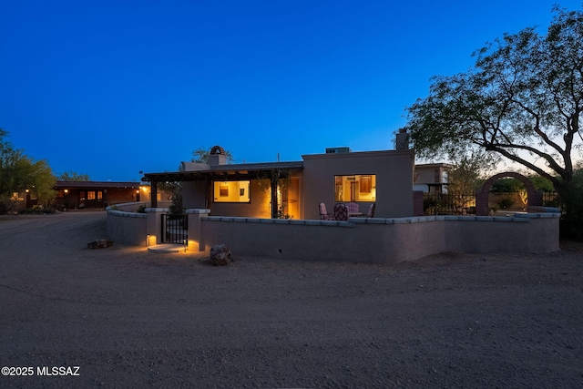 17300 S Camino Cartagena, Sahuarita, AZ 85629 - pueblo-style house with a gate, a fenced front yard, a chimney, and stucco siding