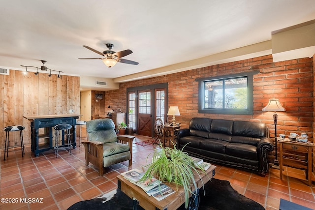 17300 S Camino Cartagena, Sahuarita, AZ 85629 - living area with tile patterned flooring, wood walls, a ceiling fan, and visible vents