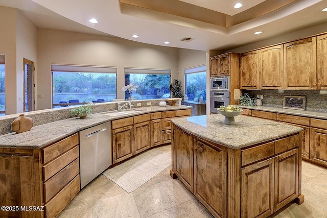 kitchen featuring recessed lighting, a center island, stainless steel appliances, and a sink