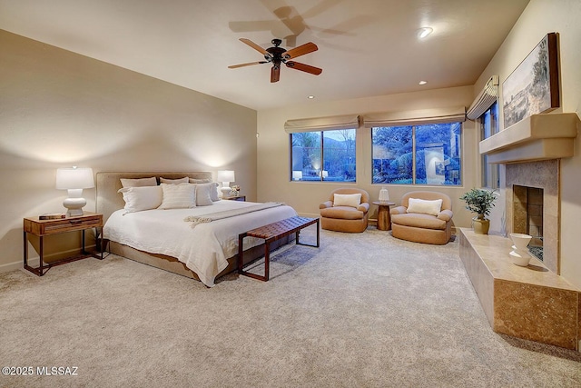 carpeted bedroom with ceiling fan, baseboards, and a tiled fireplace