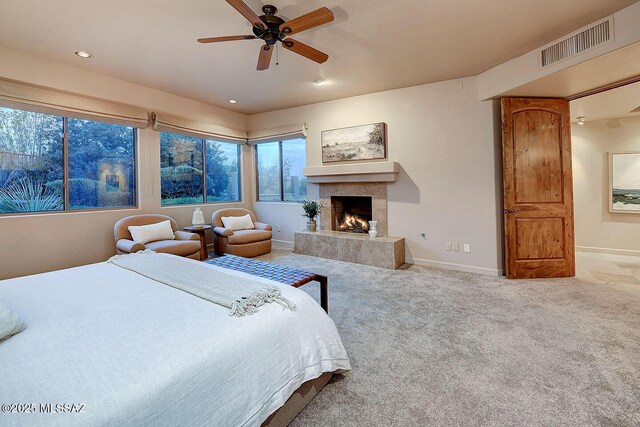 carpeted bedroom featuring baseboards, a tile fireplace, visible vents, and recessed lighting