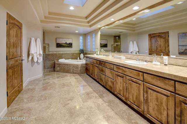 full bathroom featuring a tray ceiling, a sink, visible vents, recessed lighting, and a garden tub