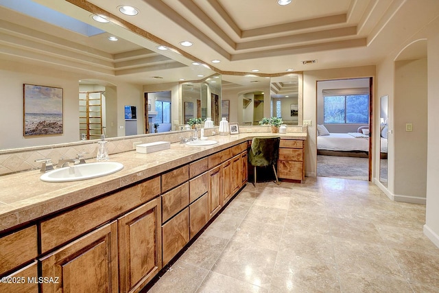 bathroom with a sink, double vanity, recessed lighting, connected bathroom, and a raised ceiling