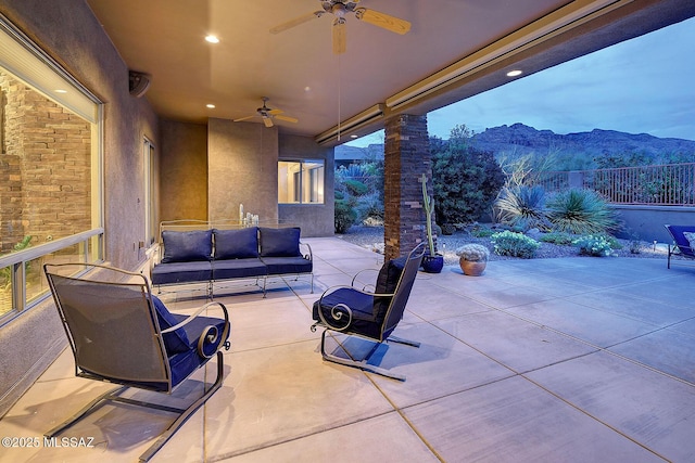 view of patio with a mountain view, fence, a ceiling fan, and an outdoor hangout area