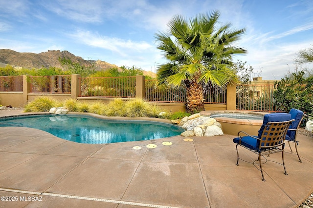 view of pool with a fenced in pool, an in ground hot tub, fence, and a mountain view