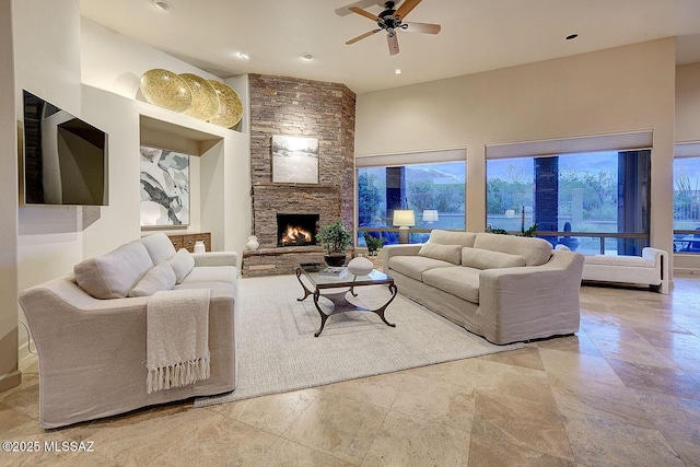 living room with a ceiling fan, stone finish floor, a fireplace, and recessed lighting