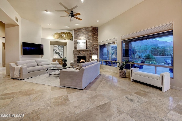 living room with a ceiling fan, stone tile flooring, a fireplace, visible vents, and recessed lighting