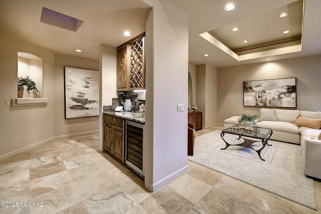 bar with arched walkways, a dry bar, wine cooler, and recessed lighting