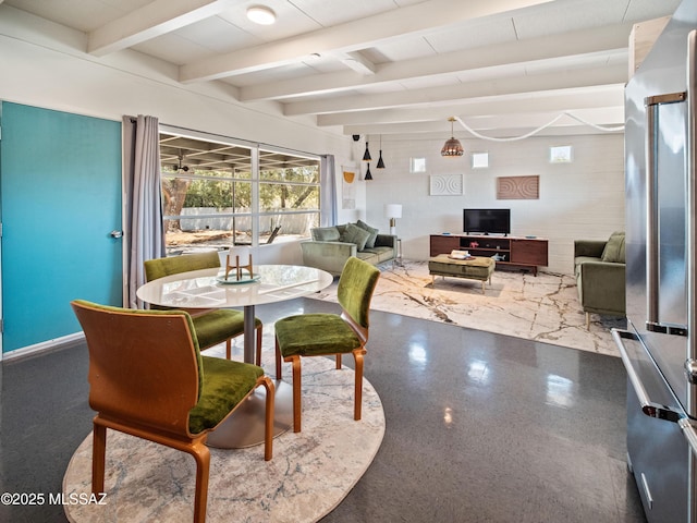 dining room with baseboards and beamed ceiling