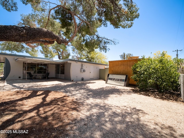 rear view of house featuring a patio and driveway