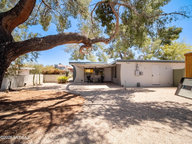 back of property with fence and a patio area
