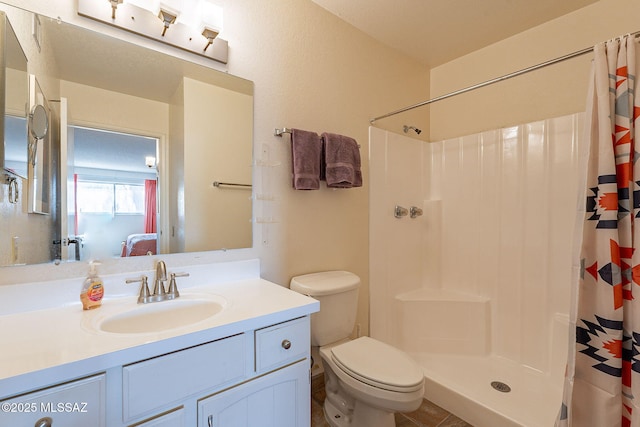 bathroom featuring vanity, curtained shower, and toilet