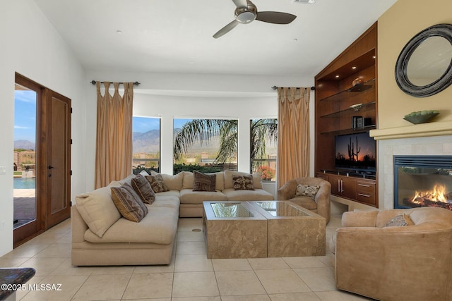 11028 N Pusch Ridge View Pl, Oro Valley, AZ 85737 - living area with light tile patterned floors, ceiling fan, and a tiled fireplace