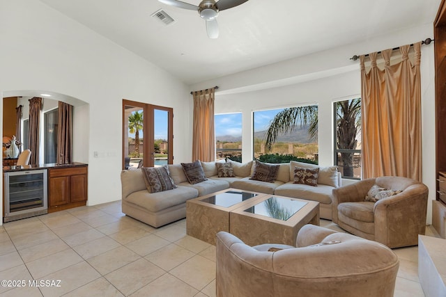 11028 N Pusch Ridge View Pl, Oro Valley, AZ 85737 - living room with beverage cooler, light tile patterned floors, ceiling fan, lofted ceiling, and bar
