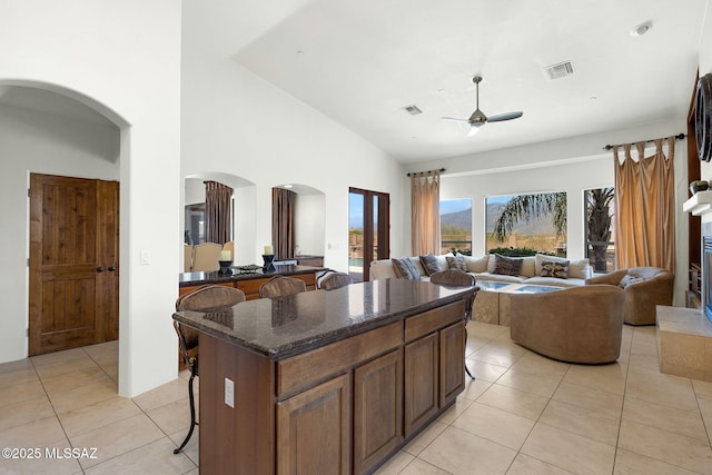 11028 N Pusch Ridge View Pl, Oro Valley, AZ 85737 - kitchen with arched walkways, a ceiling fan, a breakfast bar, a center island, and open floor plan
