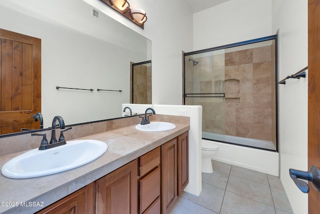 11028 N Pusch Ridge View Pl, Oro Valley, AZ 85737 - bathroom with toilet, double vanity, tile patterned floors, and bath / shower combo with glass door