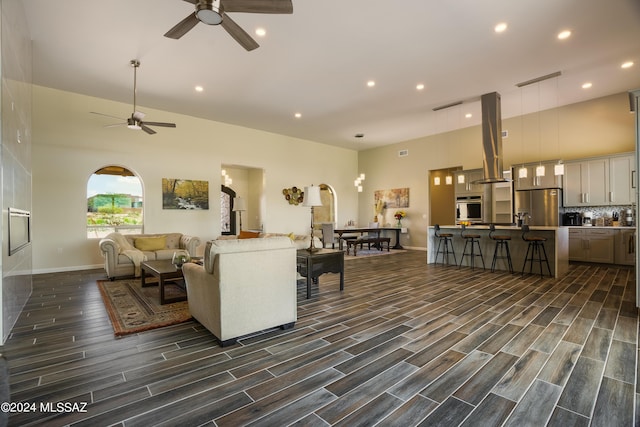 living area featuring dark wood-type flooring, a ceiling fan, baseboards, and recessed lighting