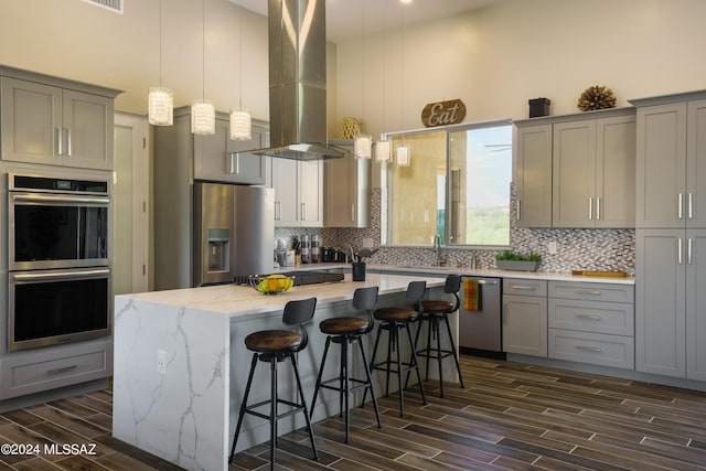 kitchen with appliances with stainless steel finishes, gray cabinets, decorative backsplash, and wood tiled floor
