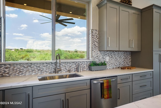 kitchen featuring ceiling fan, a sink, gray cabinets, tasteful backsplash, and stainless steel dishwasher