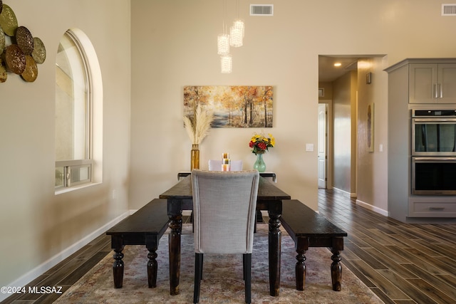 dining room with dark wood-style flooring, baseboards, and visible vents