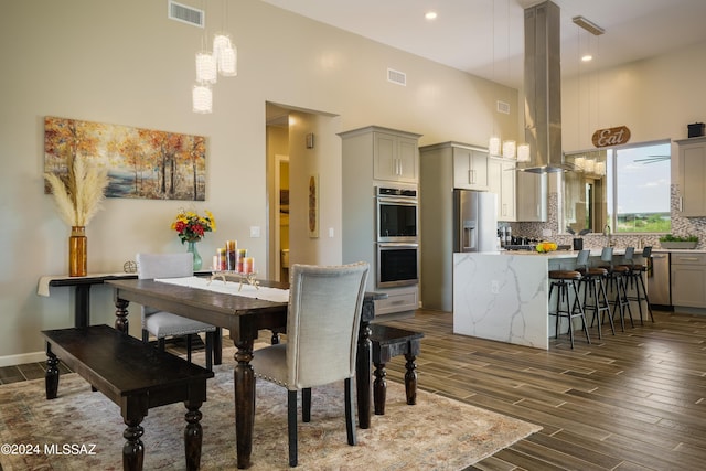 dining space featuring a high ceiling, a notable chandelier, dark wood finished floors, and visible vents