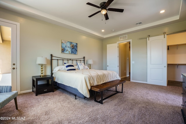 carpeted bedroom with baseboards, recessed lighting, a barn door, and visible vents