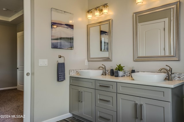 bathroom featuring a sink, baseboards, and double vanity