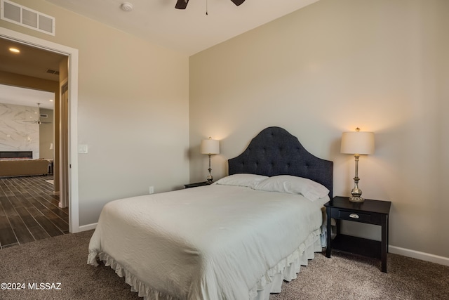 bedroom with ceiling fan, visible vents, a fireplace, baseboards, and carpet flooring