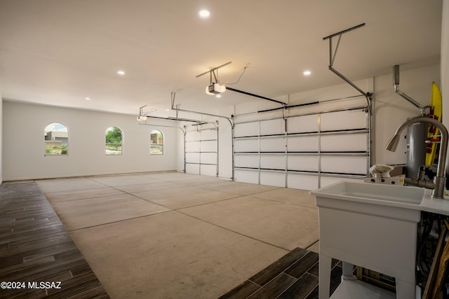 garage featuring a sink, a garage door opener, and recessed lighting