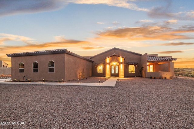 view of front of property with stucco siding and a tile roof