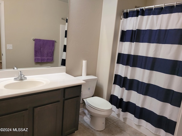 bathroom featuring tile patterned flooring, curtained shower, vanity, and toilet