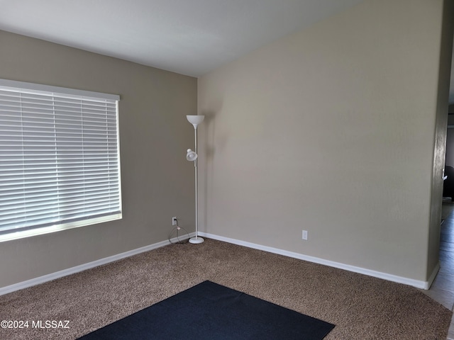 carpeted empty room featuring baseboards