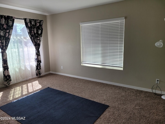 empty room featuring carpet flooring and baseboards