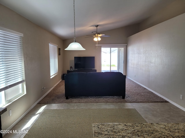carpeted living room with ceiling fan, tile patterned flooring, baseboards, and lofted ceiling